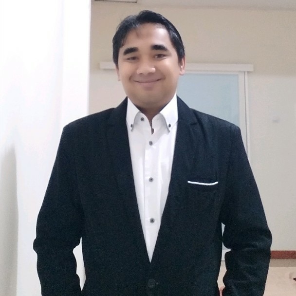 Foto Riza Nugroho mengenakan jas hitam dan kemeja putih